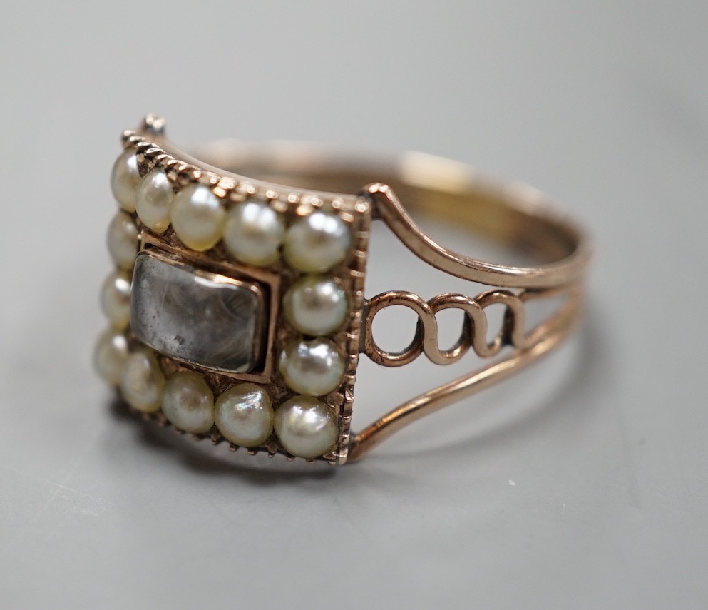A 19th century yellow metal, split pearl and plaited hair set mourning ring, with engraved monogram beneath the ring head, size T, gross weight 2.9 grams.